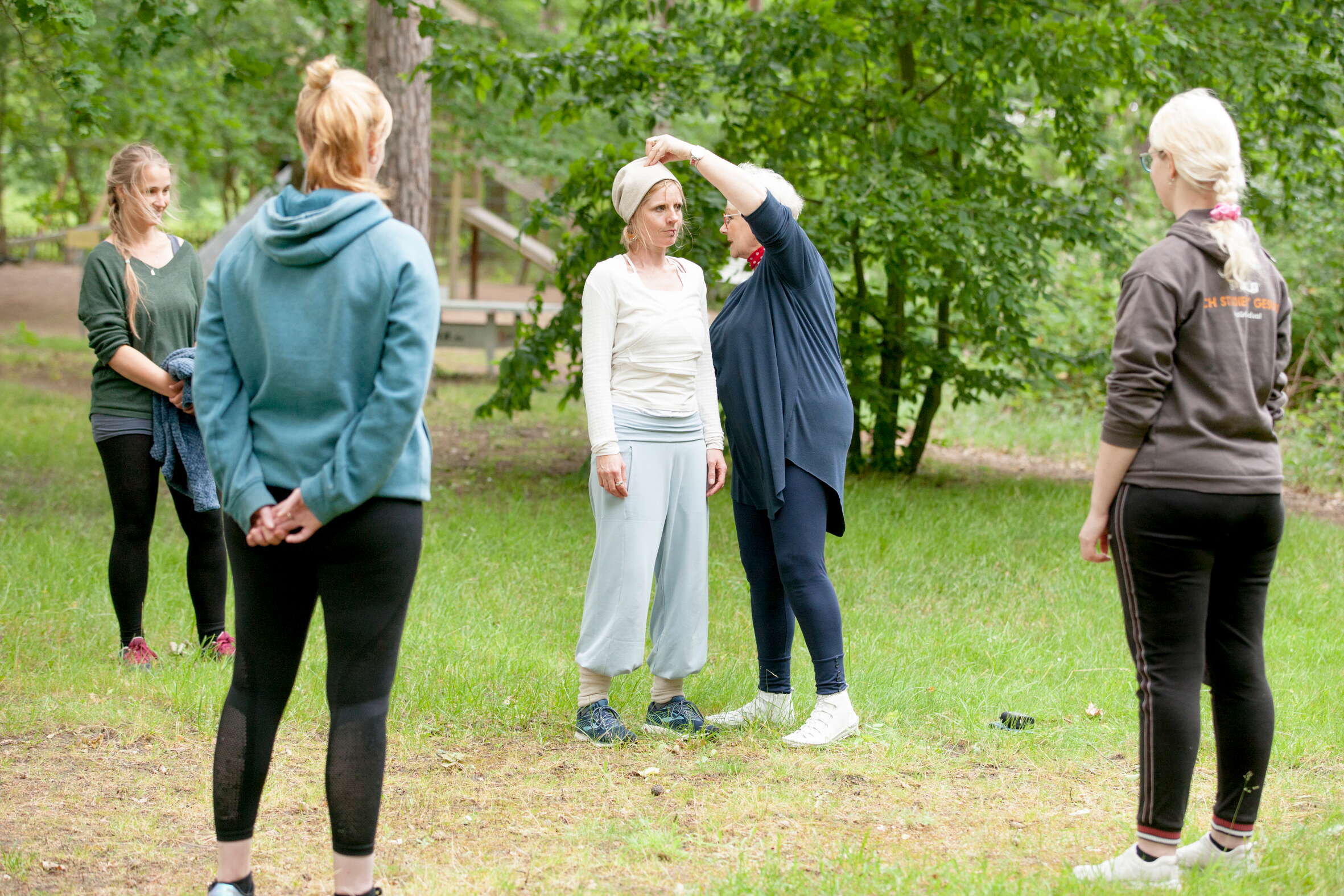 Lilli Rosinski und Anne Rosinski erklärt einer Gruppe von Frauen im Wald die Inhalte der Spiraldynamik